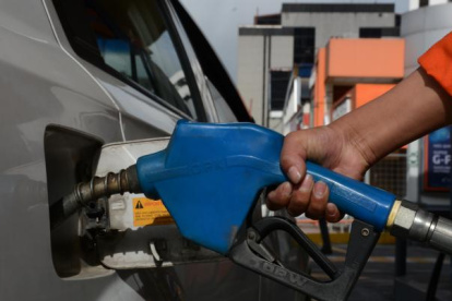 Labor.- Un trabajador llena de combustible el carro de un cliente.
