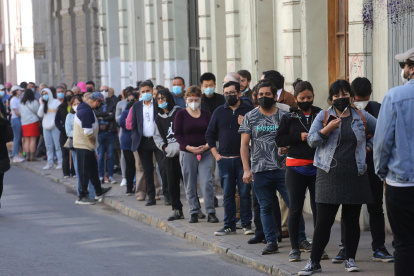 Ciudadanos hacen fila para votar el plebiscito constitucional hoy, en Santiago (Chile).