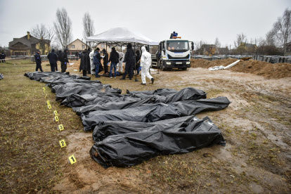 Agentes de la policía forense ucraniana exhuman cuerpos de una fosa común descubierta en Bucha, en las afueras de Kiev, el 8 de abril.
