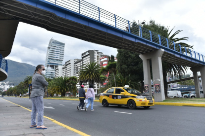 Normalizado. Las personas caminan entre los autos para llegar al otro lado de la calle.