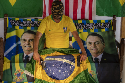 El comerciante "WJ", de 52 años, posa con dos armas de fuego que usa para su seguridad personal, el 25 de agosto de 2022, en Brasilia (Brasil). El número de civiles armados en Brasil ha aumentado un 473 % desde que el ultraderechista Jair Bolsonaro llegó al poder, en enero de 2019, y el asunto preocupa a las autoridades electorales de cara a los comicios del 2 de octubre próximo. EFE/ Joédson Alves