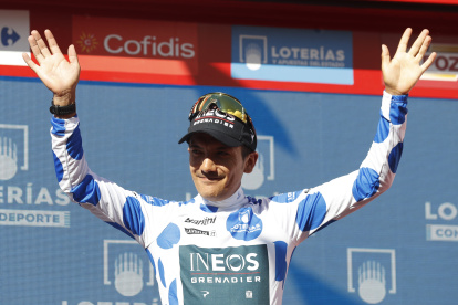 Richard Carapaz levanta los brazos con su maillot de puntos azules.