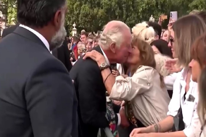 La mujer se inclinó sobre las barreras de seguridad para besar en la mejilla al rey Carlos III