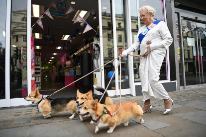 Imagen de archivo de una imitadora de Isabel II y sus perros paseando por Londres.