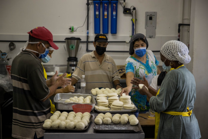 Personas preparan arepas en el marco del Día Mundial de este alimento, hoy, en Caracas (Venezuela).