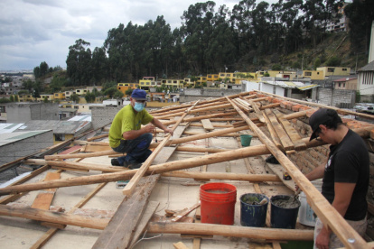 Reparación. Los hijos de una de las afectadas por el temporal reparan los techos.