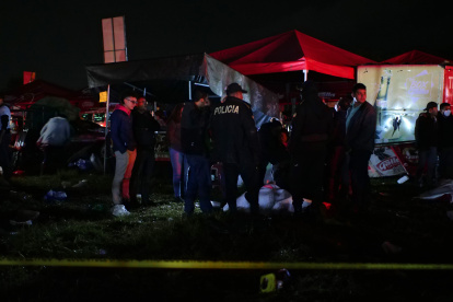 Agentes de policía resguardan los cuerpos de algunas víctimas tras una estampida en la madrugada de hoy, en Quetzaltenango (Guatemala).