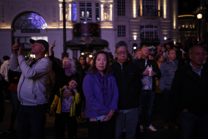 Un grupo de personas guardan un minuto de silencio por la reina Isabel II en Piccadilly Circus en Londres