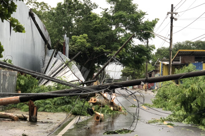 Vista de unos postes eléctricos caídos hoy después del paso del huracán Fiona por el barrio Colo en Carolina, municipio aledaño a San Juan (P.Rico). Los trabajos para restablecer poco a poco el servicio eléctrico en Puerto Rico, que sufrió un apagón general por el huracán Fiona, empezaron este lunes a obtener los primeros resultados en municipios del norte de la isla. EFE/Jorge Muñiz