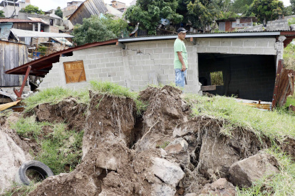 Familias observan los daños dejados por las lluvias, en Tegucigalpa (Honduras).