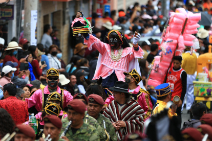 El personaje "Mama Negra" (c) recorre las calles en el tradicional rito mercedario en la cuidad de Latacunga (Ecuador).