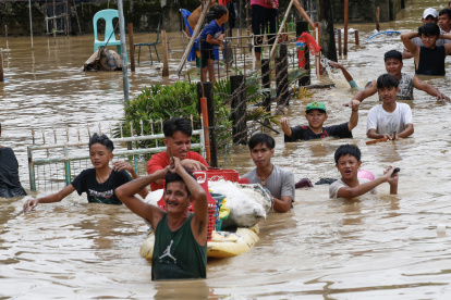 Ciudadanos caminan con el agua hasta la cintura debido a la inundación provocada por el tifón Noru en la localidad de San Miguel de Bulacan, en la isla de Luzón, Filipinas. EFE/EPA/ROLEX DELA PENA