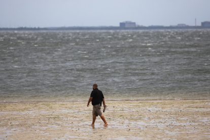 Un hombre camina a lo largo de una costa en Tampa, Florida, EE. UU., el 28 de septiembre de 2022.