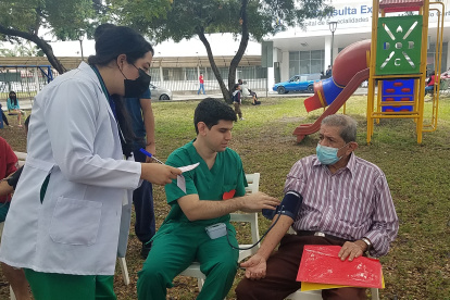 Médicos  internos del hospital Teodoro Maldonado Carbo le toman la presión a Jorge Avilés, paciente con hipertensión.