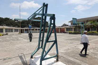 En ruinas. Dos personas recorren la zona de canchas del complejo de Asenir. Los pocos alumnos que hay no las usan por el deterioro.