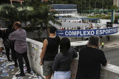Ciudadanos brasileños esperan en una fila para votar en un centro de votación hoy, en Río de Janeiro (Brasil).