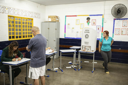 Ciudadanos brasileños llegan a una mesa de votación hoy, en una escuela de Brasilia (Brasil)