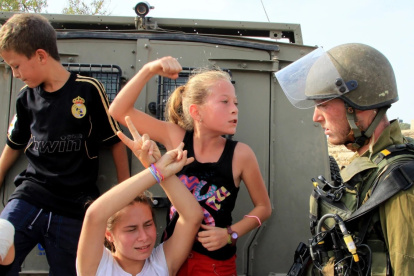 La niña palestina Ahed Tamimi (centro) desafía a los soldados israelíes durante una protesta en Cisjordania.
