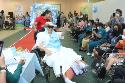 Guido Caputti, integrante del Hogar Villa Esperanza # 2, se pasea por la alfombra roja con la ayuda de su cuidadora, durante el Geronto Fashion.