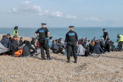 Oficiales de policía y de la institución de salvavidas junto a migrantes que fueron rescatados en el Canal de la Mancha, en Dungeness, Reino Unido, el 22 de septiembre.