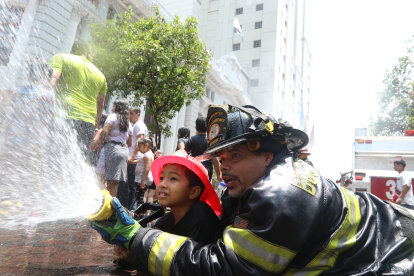 Los bomberos enseñaron a los niños a manejar una manguera para apagar un incendio.