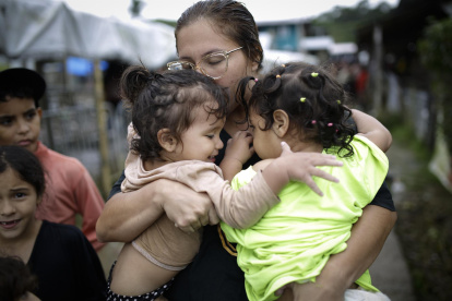 Dairana Moreno, migrante venezolana de 30 años, carga a su hija Salma Bracho (i) y otra menor, el 13 de octubre de 2022, en el pueblo de Bajo Chiquito (Panamá).