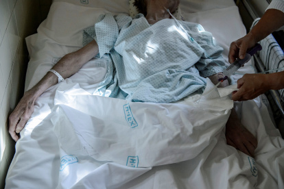 Un profesional sanitario alimenta a un paciente a través de una sonda en el Departamento de Cuidados Paliativos del Hospital Markhot Ferenc en Eger, en Hungría, el 27 de septiembre de 2019.