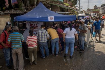U grupo de personas mientras reciben ayuda gubernamental en una barriada afectada por lluvias, en Las Tejerías (Venezuela). EFE/Miguel Gutiérrez