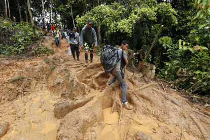Migrantes venezolanos suben una montaña con la intención de llegar a Panamá, en el Tapón del Darién (Colombia).
