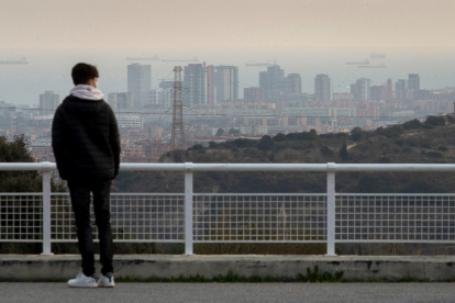 Vista de marzo de 2021 de una persona joven observando el paisaje de Barcelona.