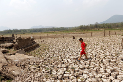 Un niño recorre una zona seca en un embalse, en una fotografía de archivo.