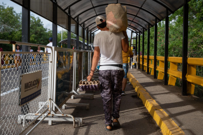 Un hombre mientras carga un mercado por el Puente Internacional Simón Bolívar, Cúcuta, Norte de Santander (Colombia). EFE/Rayner Peña R.