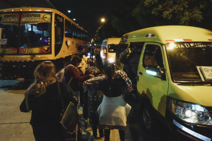 Migrantes venezolanos se embarcan en furgonetas para trasladarse a albergues provisionales.
