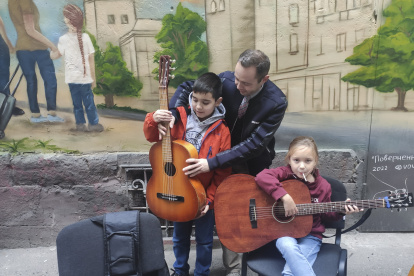 LEOPOLIS (UCRANIA), 26/10/2022.-Andriy Saravas, un músico de Mariúpol de etnia griega, ofrece clases de guitarra para los niños en el centro de asistencia "Yo soy Mariúpol" en una estrecha calle en el centro de Leópolis. El centro trata de ayudar a niños y a adultos a través del aprendizaje de nuevas habilidades, explorando la ciudad de Leópolis o a través de la interacción con animales. Según el presidente del centro, Andriy Vasylenko, en el mismo se han registrado ya más de 3.100 desplazados de Mariúpol, la mayoría de los cuales han perdido todas sus pertenencias y dependen de la ayuda que reciben de organizaciones humanitarias y de los residentes locales en forma de alimentos, ropas o incluso sillas de ruedas para las personas con discapacidad. También acuden al centro para recuperar, al menos temporalmente, la sensación de estar en casa y para recibir ayuda psicológica. EFE/ Rostyslav Averchuk