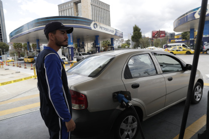 Fotografía de archivo en la que se registró a un operario al llenar de combustible el tanque de un automóvil en una estación de suministro de Petroecuador, en Quito (Ecuador).