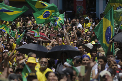 Centenas de personas se concentran en un pasadizo para acompañar el presidente brasileño Jair Bolsonaro en un acto de campaña presidencial, hoy en la ciudad de Sao Joao de Meriti, en Río de Janeiro (Brasil). EFE/Antonio Lacerda