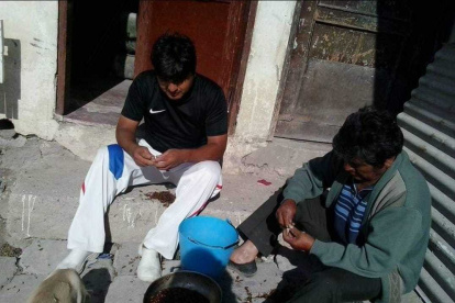 Tarea. Édison Pilatuña y su padre sacan las alas de los catzos antes de dejarlos en agua con sal.