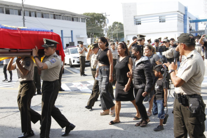 Los familiares de los policías asesinados acompañaros sus féretros en el recinto policial.