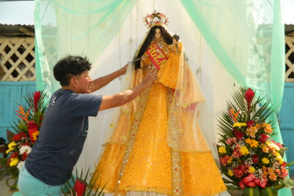 A la Virgen. El artesano da los últimos toques al traje con el que se engalana a la Virgen del Cisne.