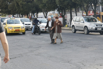 Irrespeto. Una pareja de la tercera edad cruzó la avenida Eloy Alfaro por donde mejor pudo. No existe ni siquiera un paso cebra trazado en la vía.