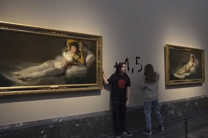 Captura de video del momento en el que dos activistas de la organización Futuro Vegetal se han pegado a los marcos de los cuadros de "La maja vestida" y "La maja desnuda" del Museo del Prado y han escrito en la pared "+1.5°" en referencia al anuncio de la ONU de la imposibilidad de cumplimiento del Acuerdo de París. EFE/Futuro Vegetal -