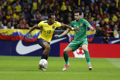 El centrocampista de la selección de fútbol de Irak Ibrahim Alkaabawi (d) lucha con Romario Ibarra, de la selección de Ecuador, durante el encuentro amistoso de preparación para el mundial de Qatar que los combinados nacionales de Ecuador e Irak disputan este sábado en el estadio Civitas Metropolitano, en Madrid. EFE/J.J Guillén