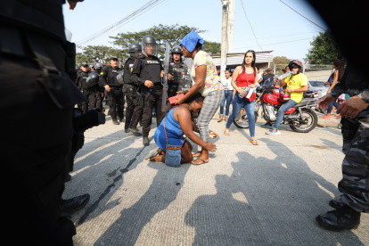 Familiares de internos tratan de consolorase mutuamente en medio del ambiente de caos que se registra en los exteriores de la Penitenciaría del Litora, durante una nueva jornada de enfrentamientos con muertes al interior de ese centro carcelario.
