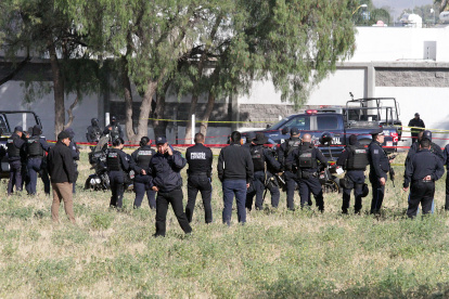 Agentes de la policía observan los restos del accidente del helicóptero de la Secretaría de Seguridad Publica estatal hoy, en la ciudad de Aguascalientes (México). Un helicóptero se desplomó este jueves en el estado de Aguascalientes, en el centro de México, y cuatro personas fallecieron en el accidente, entre ellos el secretario de Seguridad del Estado, Porfirio Javier Sánchez, confirmó la gobernadora, Teresa Jiménez, a través de Twitter. EFE/Sebastián López