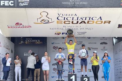 El ciclista colombiano Robinson Chalapud (c) con el maillot amarillo y el trofeo como campeón de la Vuelta al Ecuador.