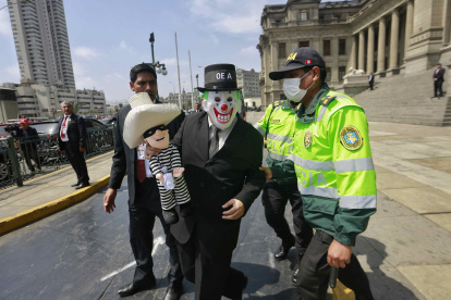 Un manifestante en contra de la visita de la delegación de la OEA fue registrado este lunes, 21 de noviembre, al protestar fuera del palacio de Justicia, en Lima (Perú). EFE/Paolo Aguilar