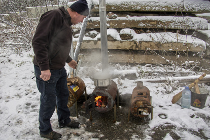 Un hombre utiliza una estufa de leña móvil en Járkov, Ucrania, el 18 de noviembre de 2022 en medio de la invasión militar de Rusia. EFE/EPA/SERGEY KOZLOV