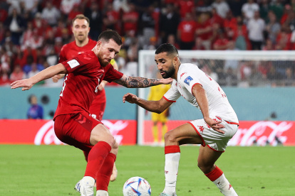 Pierre-Emile Hojbjerg (L) de Dinamarca en acción en contra Ali Abdi (R) de Túnez durante el partido del grupo D partido de fútbol entre Dinamarca y Túnez en Estadio de Ciudad de la Educación en Doha.