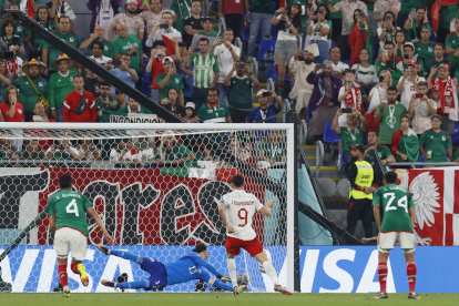 Guillermo Ochoa (c) México ataja un penalti a Robert Lewandowski (i) de Polonia hoy, en un partido de la fase de grupos del Mundial de Fútbol Qatar 2022 entre México y Polonia en el Estadio 974 en Doha (Qatar).