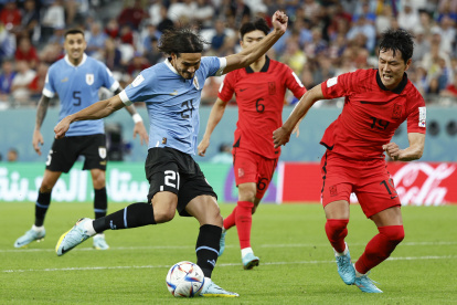 Edinson Cavani (i) de Uruguay disputa un balón con Kim Young-gwon de Corea del Sur hoy, en un partido de la fase de grupos del Mundial de Fútbol Qatar 2022 entre Uruguay y Corea del Sur en el estadio Ciudad de la Educación en Rayán (Qatar).